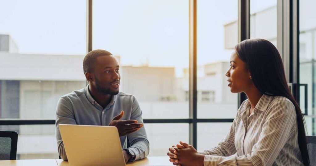Two professionals conducting mock interview preparation practice session in modern office conference room